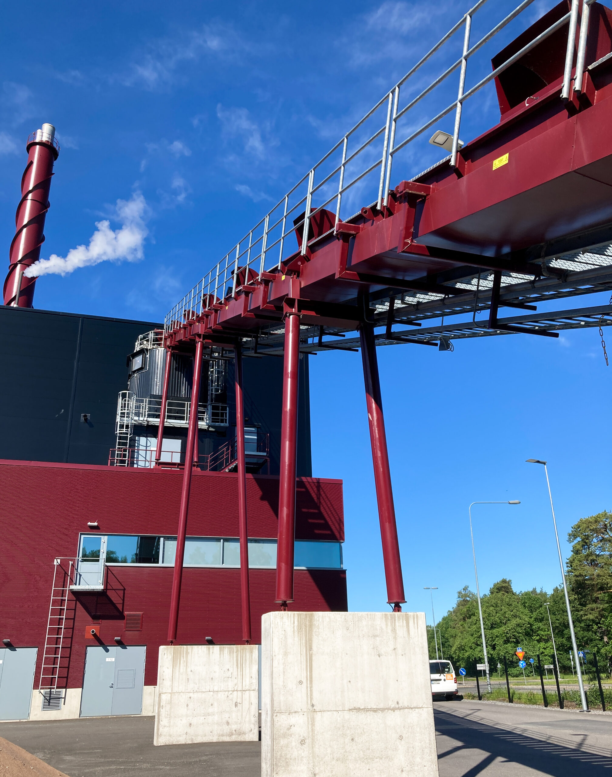 Red conveyor feeding biomass into day silo.