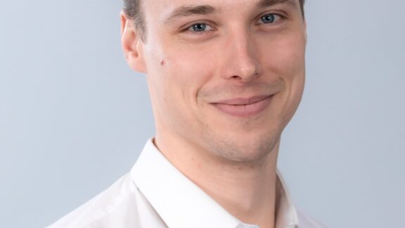 Face portrait of a man wearing a white collared shirt.