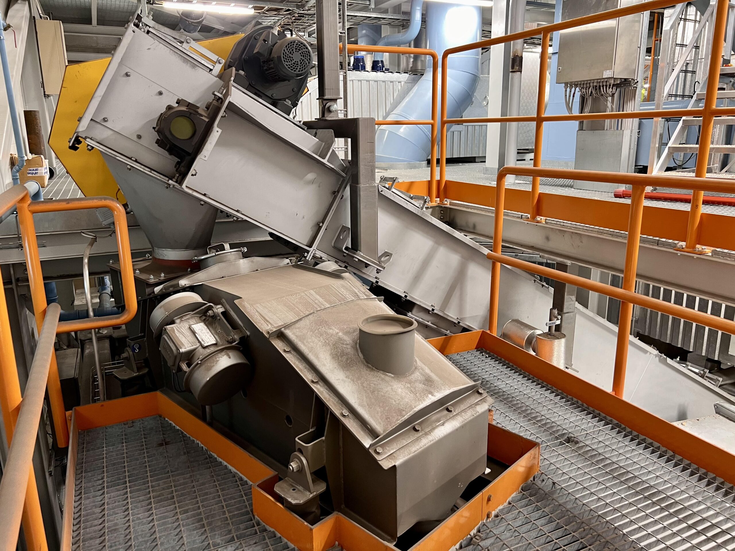 Grey chain conveyor feeding biomass in to the process.