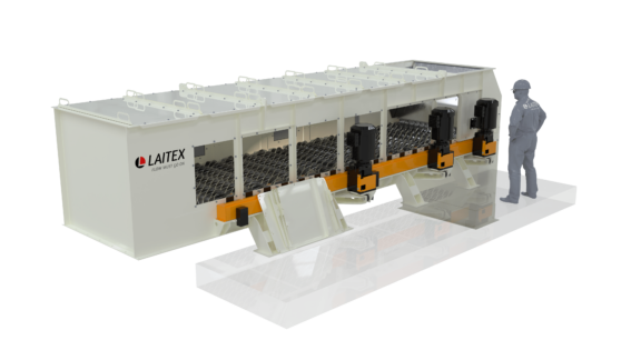 An engineer standing beside disc screen that is used for material separation..