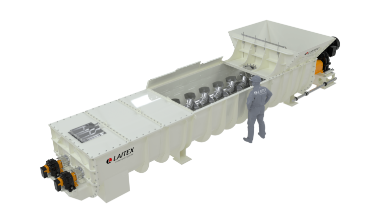 An engineer standing beside a twin screw mixer.