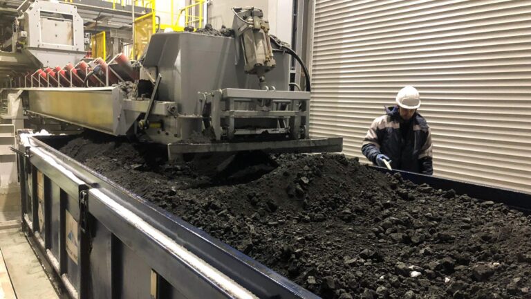 Container loading system and a man standing beside a container.